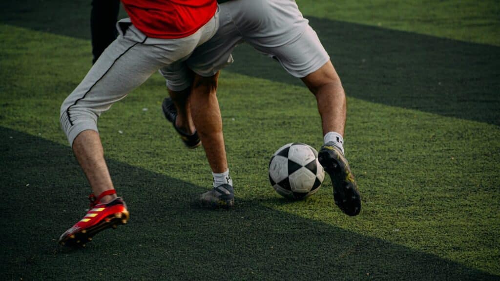 two men are playing soccer on a field