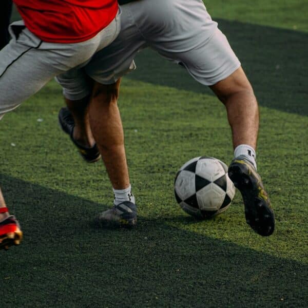 two men are playing soccer on a field