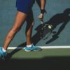 woman holding tennis ball and racket