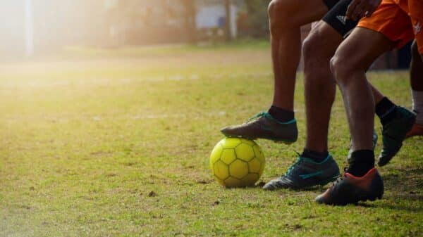 man in black shorts and black nike soccer ball on green grass field during daytime