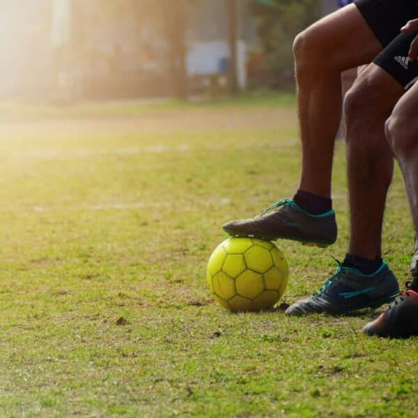man in black shorts and black nike soccer ball on green grass field during daytime