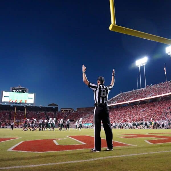a football player standing on a field with his arms in the air